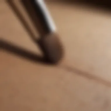 Makeup Brush Ready for Application A stylish makeup brush poised over light brown matte eyeshadow.