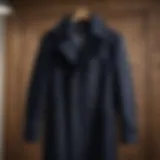 Classic navy peacoat displayed on a wooden hanger